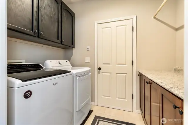 Main level laundry with storage leads to large 3-car garage.