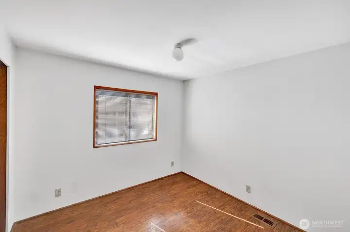 Guest bedroom on West side of home has window view of yard. Room will accommodate a queen-sized bed , nightstands and more furniture.