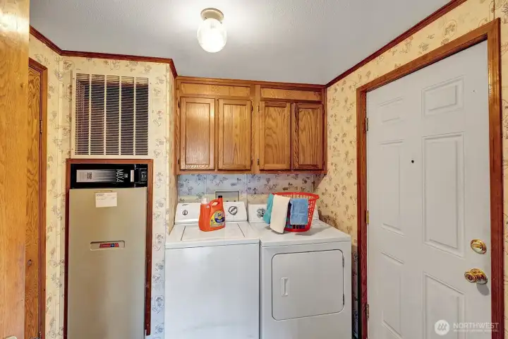 Large utility room has washer and dryer, storage cabinets and room for freezer or other necessities.