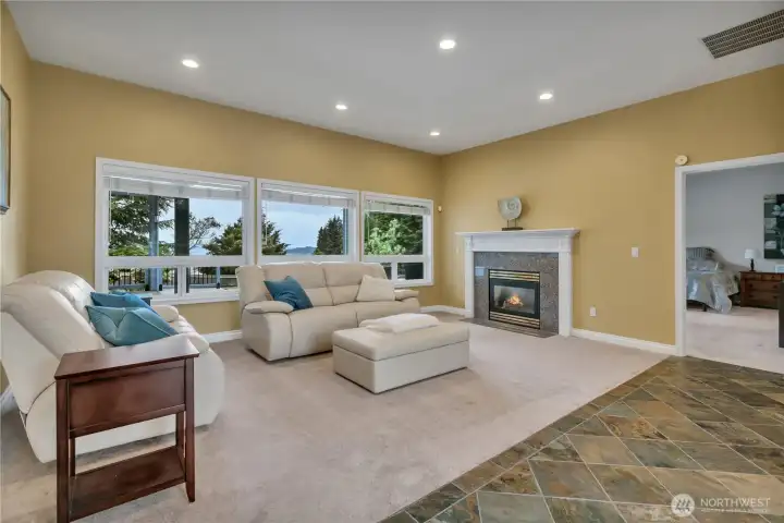 Living space enhanced by three view-filled windows that bring in natural light and scenery. The gas fireplace adds warmth and a cozy focal point to the room.