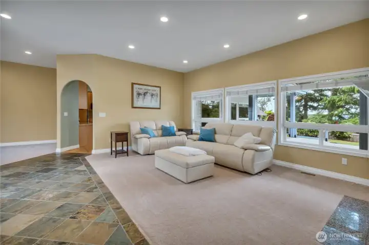 Another view of the living area featuring an elegant arched doorway that seamlessly connects to the kitchen, enhancing the home’s open and inviting flow.