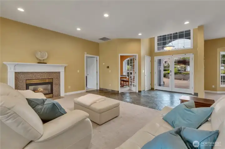 Another view of the living area featuring the den/office behind elegant French door, with access to the primary suite located just to the left.