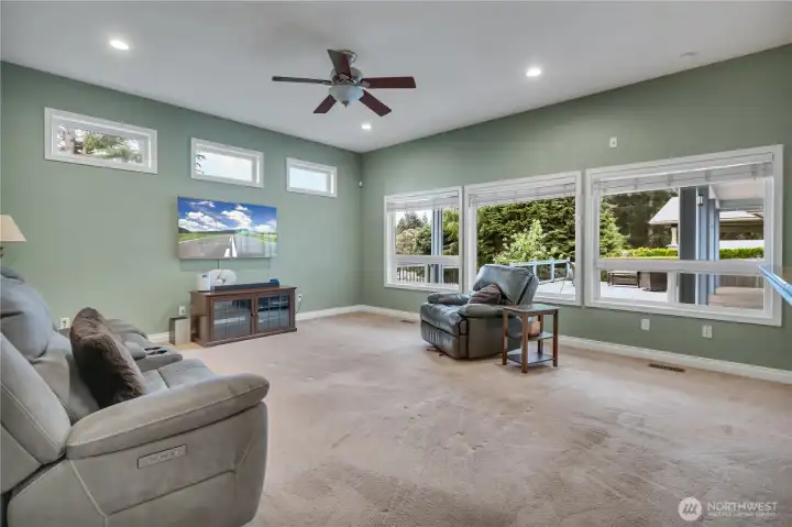 The family room is graced with three large view-filled windows that bring in abundant natural light, along with three additional windows that further brighten the space.
