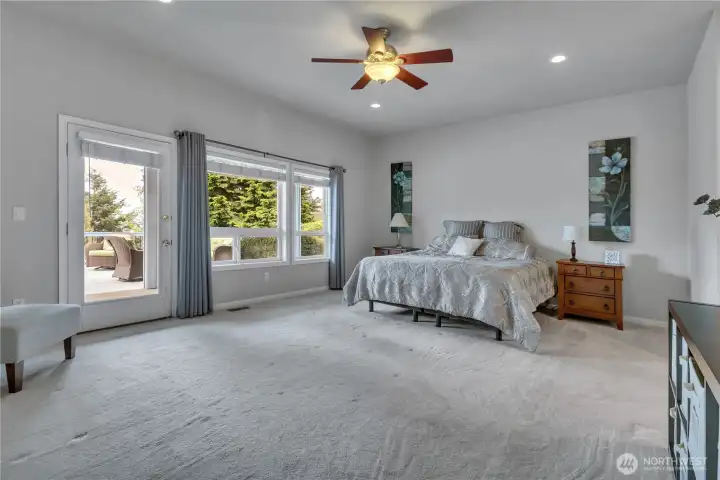 The spacious primary suite features glass door access to the deck, creating a peaceful retreat perfect for relaxation and enjoying the views.