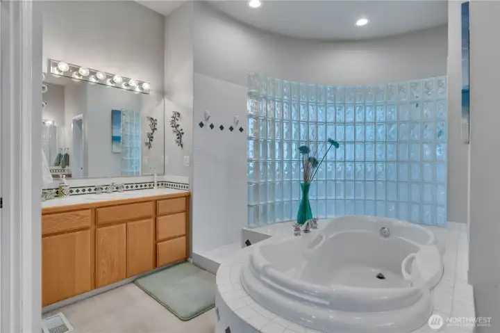 Spa-inspired primary ensuite featuring a stunning glass block shower and designer soaking tub—perfect for relaxing and unwinding at the end of the day.