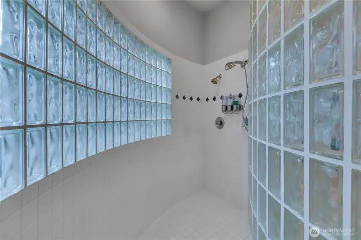 The glass block shower in the primary ensuite offers great space and beautiful natural light, creating a bright and relaxing spa-like feel.