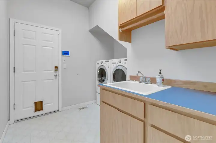 Spacious utility room featuring a sink, additional counter space, and cabinetry for added storage and functionality.