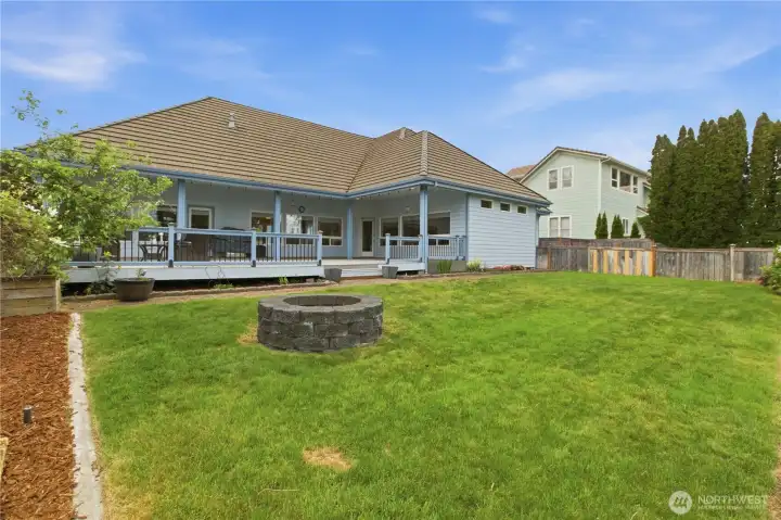 View of the home’s exterior and deck from the backyard, showcasing the outdoor living space and overall setting.