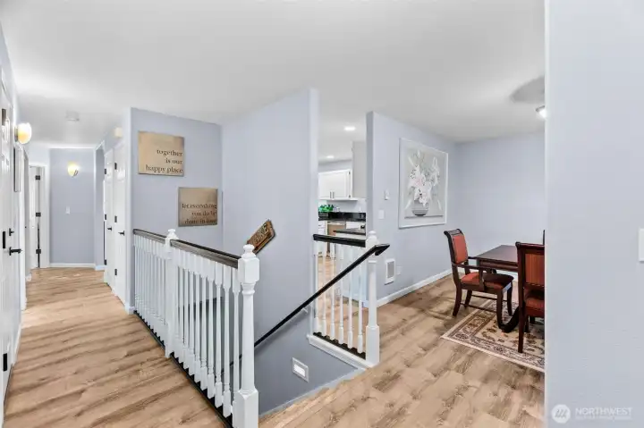 Just inside the front door on the main level, you see a large entry closet and hallway to bathroom & primary bedroom on the left, stairway to the lower level, and dining room & a peek of the kitchen & living room beyond ont the right.