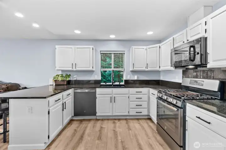 Stunning updated kitchen with granite counters, undermount sink and stainless steel appliances. Cabinets are beautifully refreshed with new paint and hardware.