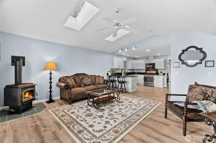This view from the living room shows the newer skylights (2022) looking into the kitchen. The hallway and primary suite are to the right beyond the chair.