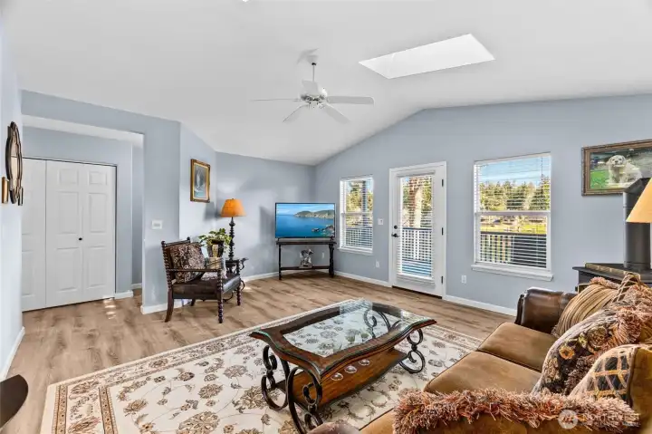 Vaulted ceilings make this space open and airy. The washer & dryer are to the left in this photo with primary suite to the right. All appliances convey with the home sale. Everything you need is already in place.