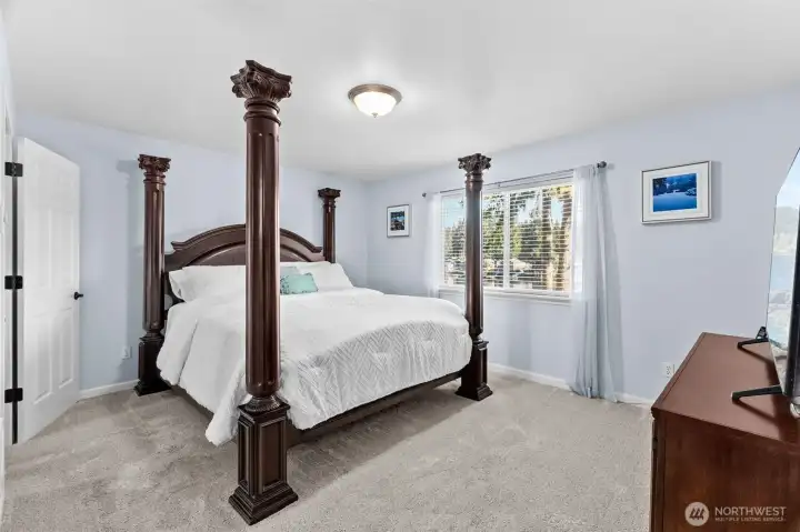 The dreamy primary suite offers new plush carpeting, lake views, a large walk-in closet and fully updated bathroom.