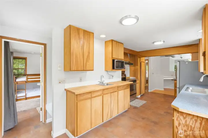 Functional kitchen with adjacent built-in desk area, ideal for remote work, household organization, and meal preparation. Functional kitchen with adjacent built-in desk area, ideal for remote work, household organization, and meal preparation.