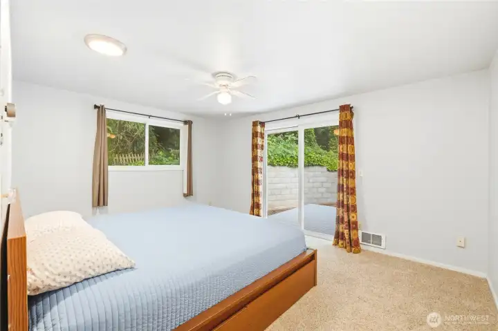 Primary bedroom with sliding door access to back yard deck. Primary bedroom with sliding door access to back yard deck.