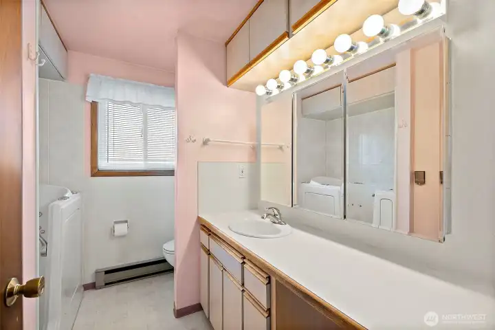 Large bathroom with large soaker tub & shower handle above. Vanity area has plenty of space to accommadate a double sink upgrade.