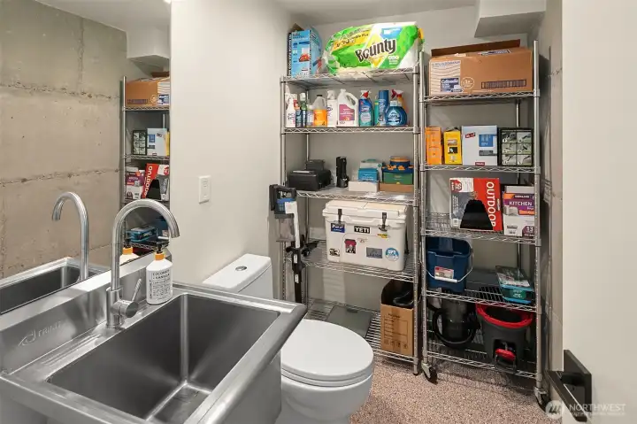 This half bath and storage area could easily accommodate a shower, if desired. On the other side of the wall at left, plumbing could be routed to add a kitchenette.