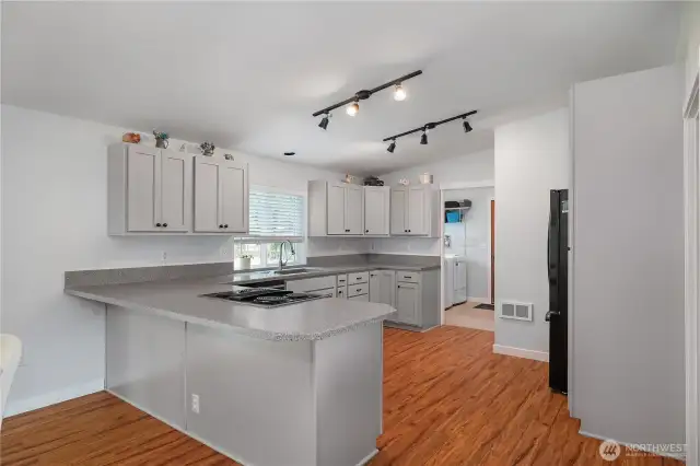 Freshly remodeled with sleek gray cabinets,  hard surface counters, new dishwasher/refrigerator and plenty of storage.