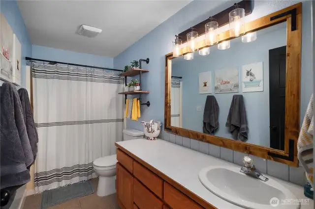 This clean and functional main bathroom offers updated fixtures and easy-to-clean surfaces.
