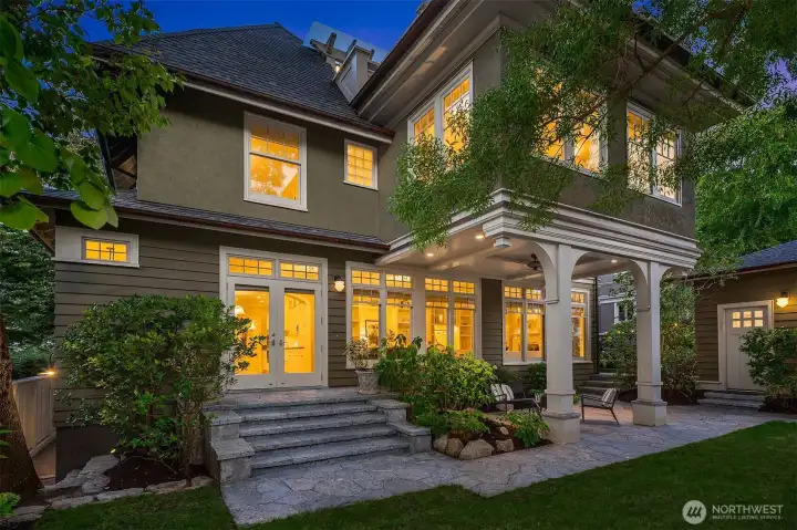 Professionally designed gardens define the property in luxurious established green. Here, French doors offer a gracious extension of the kitchen and sunroom.