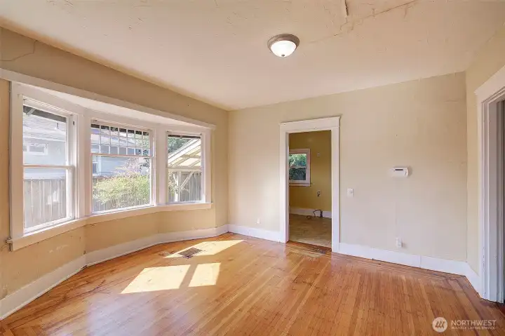 Huge bay window in the dining room. The kitchen is through the doorway in the back. Maybe make the opening to the kitchen wider, or open it up entirely.