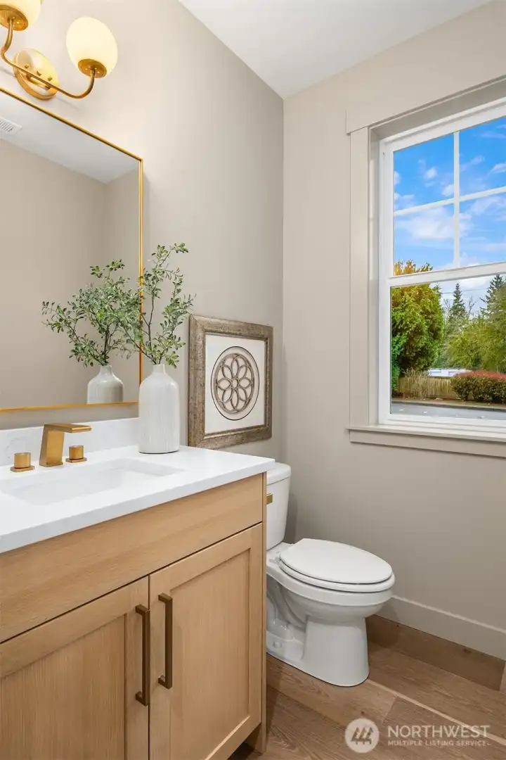 Main floor powder room has elegant brushed gold faucet and hardware