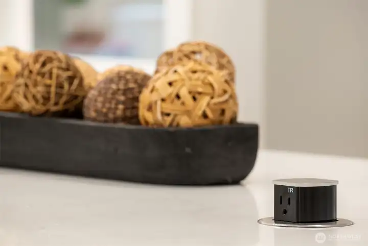 Kitchen island has convenient pop up outlets.