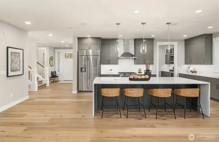 Huge center island with accent cabinet color & waterfall quartz top