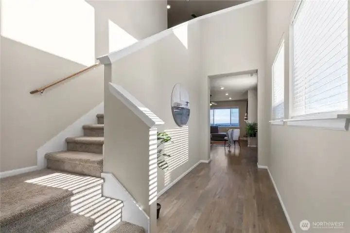 Interior stair and entry perspective with an open layout that connects the main level well