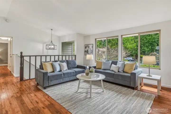 Looking toward the front entry, large updated vinyl windows fill the living room with natural light