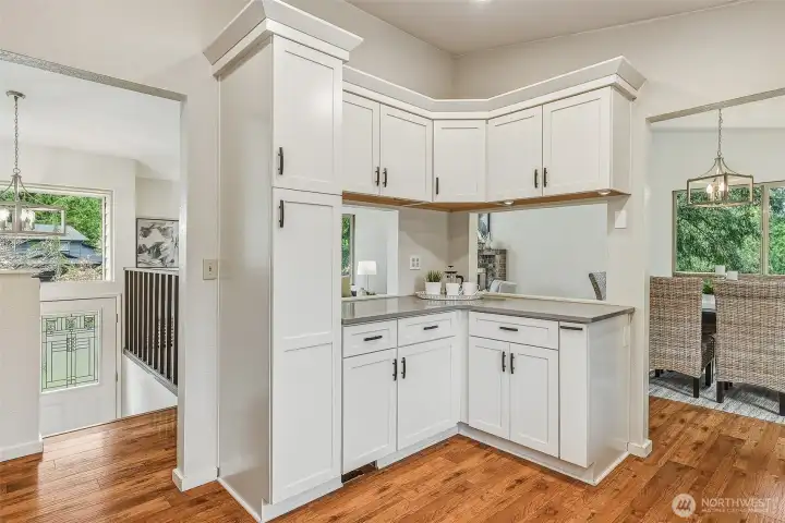 Kitchen looking towards the entry, living room, and dining room. The walls were opened up to make it semi-open concept while preserving storage. The dropped ceiling was removed, making the space feel larger