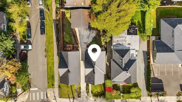 Top down view of lo featuring driveway, detached garage & carport.