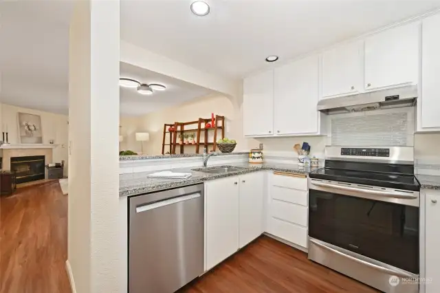 Light filled kitchen with new stainless dishwasher and range. Gorgeous slab granite counters compliment the stylish tile backsplash.