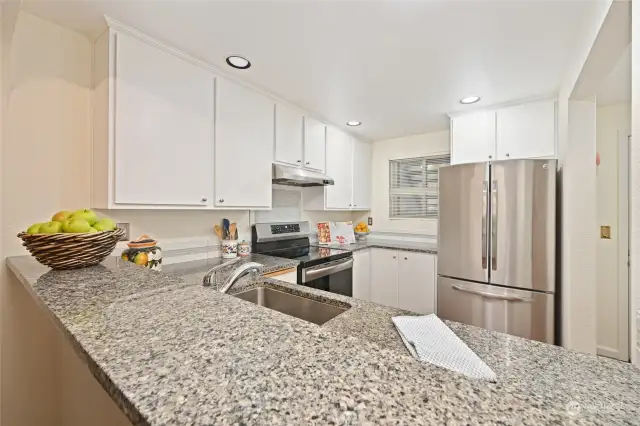 Chefs kitchen with new granite slab countertop and breakfast bar. Stainless appliances.