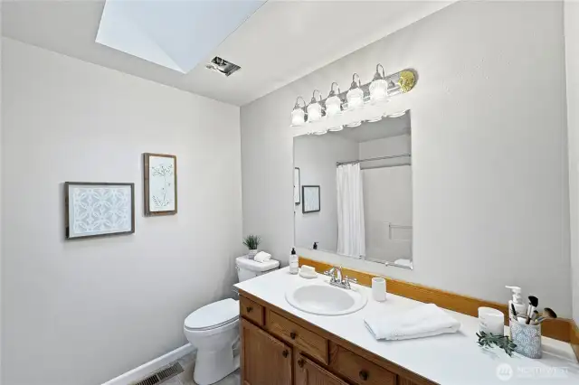 The full bath on the main floor is bathed in natural light coming from the skylight above.