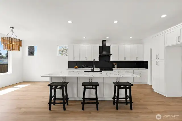 Sleek white cabinets offer storage galore. Soft close doors & drawers. Recessed can lighting, custom chandelier, black and stainless appliances blend the space.