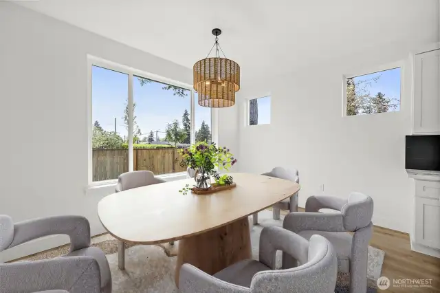 The dining space overlooks the backyard and offers ample space for lots of guests. Natural light fills the room.