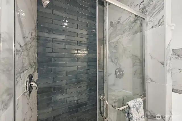 Beautiful tile work lines the double headed shower.