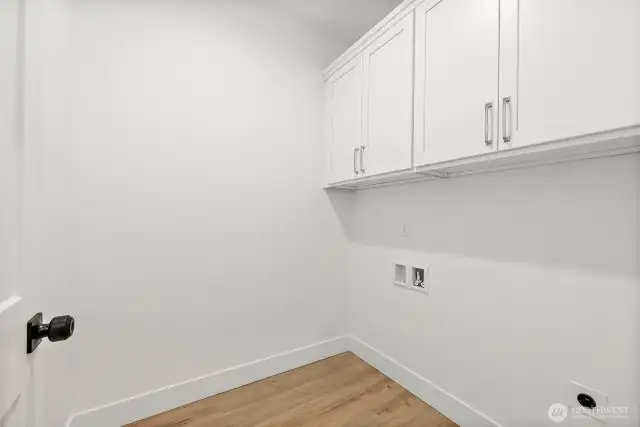 Laundry room offers additional storage.