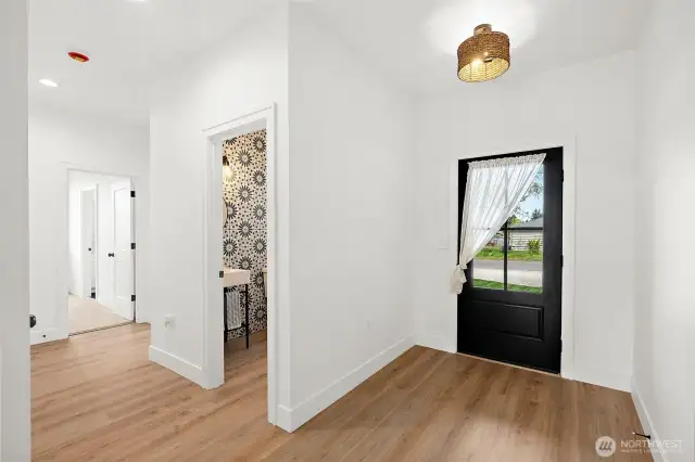 As you enter you are greeted by beautiful and versatile LVP floors that play off of the white mill work. Custom lighting and dark hardware offer a stylish modern look.
