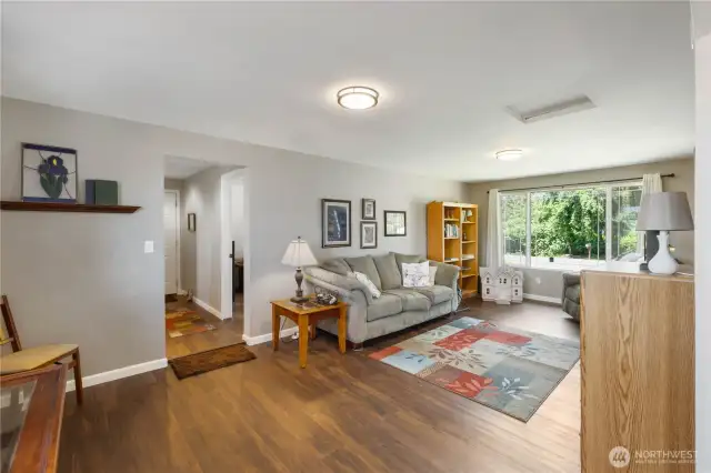 There is room for another dining room table on the left side of this photo.  The family room is perfect to sit and watch your favorite movie or enjoy a great book. Down the hall on the right is a bonus room, to the left of the hall is a bathroom room and a large laundry room.  At the end of the hall is the garage access door.