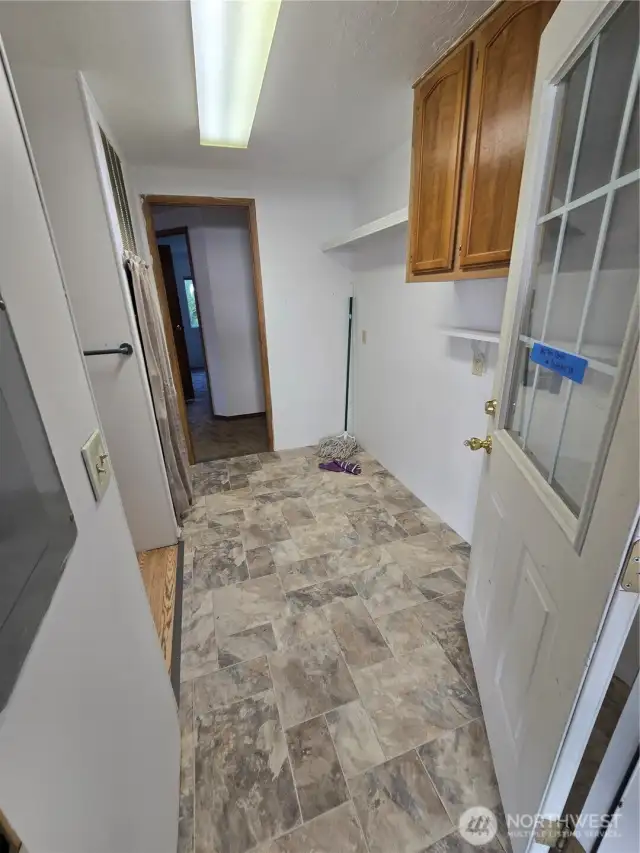 Utility room with washer/dryer hook ups, additional cabinets/shelves for storage, furnace & water heater