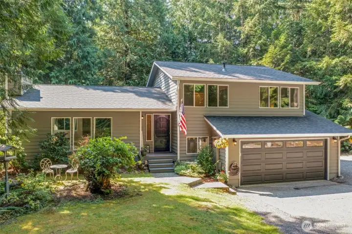 The home’s inviting entry is complemented by vibrant landscaping. The covered steps and thoughtfully placed lighting create a warm welcome for you and your guests.