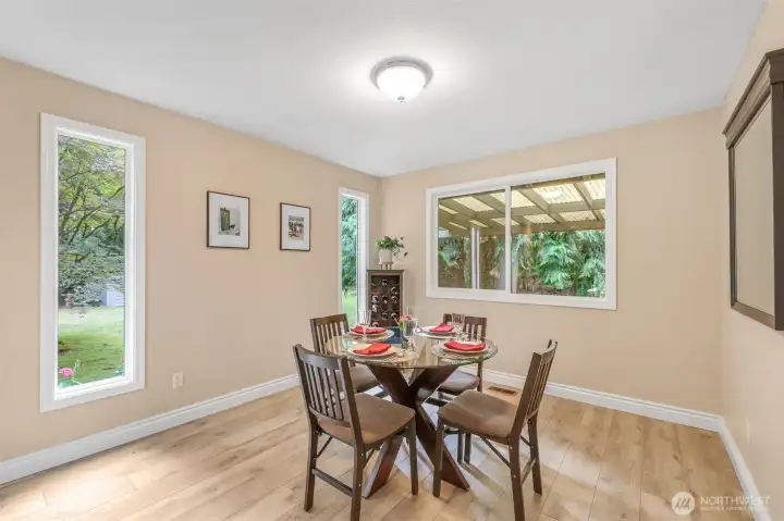 The dining area is designed for both casual meals and special occasions. Natural light streams through multiple windows, offering peaceful views of the surrounding greenery.