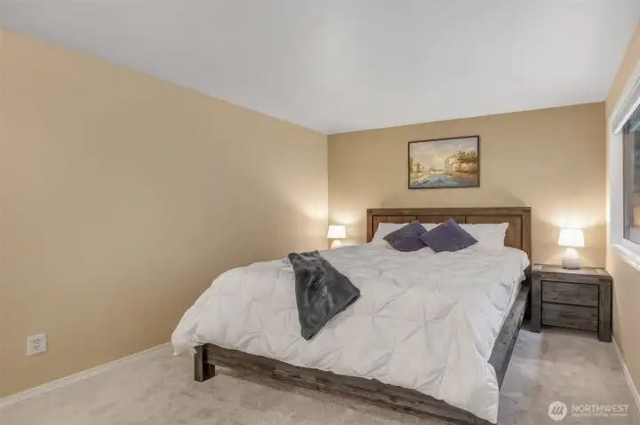 Another angle of the primary suite shows its generous proportions and inviting atmosphere. Neutral finishes make it easy to personalize and create your own sanctuary.