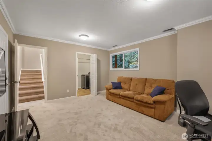 Looking back toward the stairwell, you’ll notice the easy flow from the bonus room to the laundry area. Conveniently located on the lower level, this layout makes everyday living a breeze.