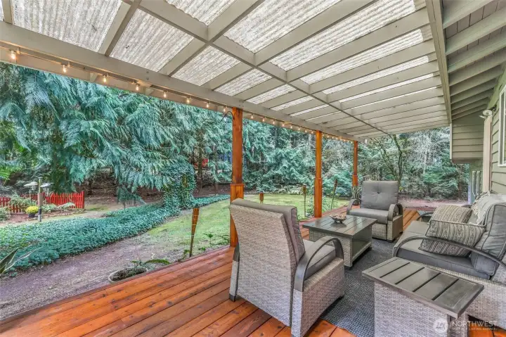 The covered back deck extends your living space into the outdoors, offering year-round enjoyment rain or shine. Surrounded by mature evergreens and lush landscaping, it’s the perfect setting for morning coffee, evening barbecues, or simply relaxing while taking in the peaceful, park-like surroundings.