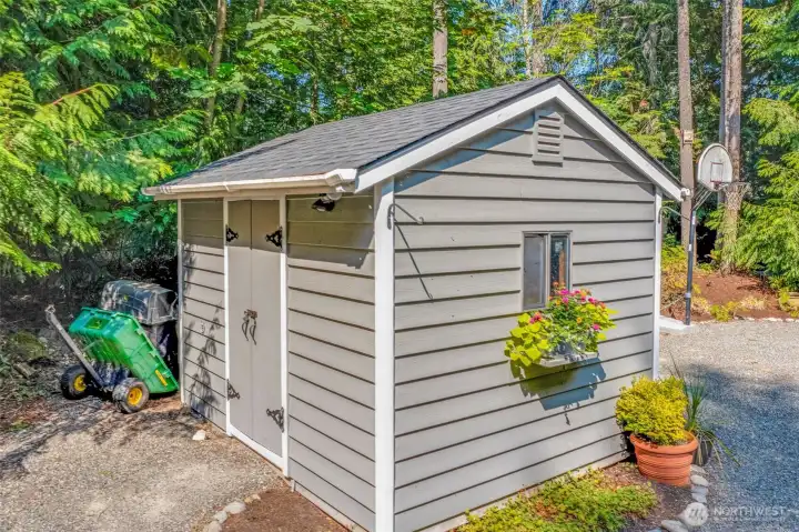 The shed is a valuable addition for yard tools, seasonal gear, or hobby space. Its location near the driveway makes it convenient and easy to access.