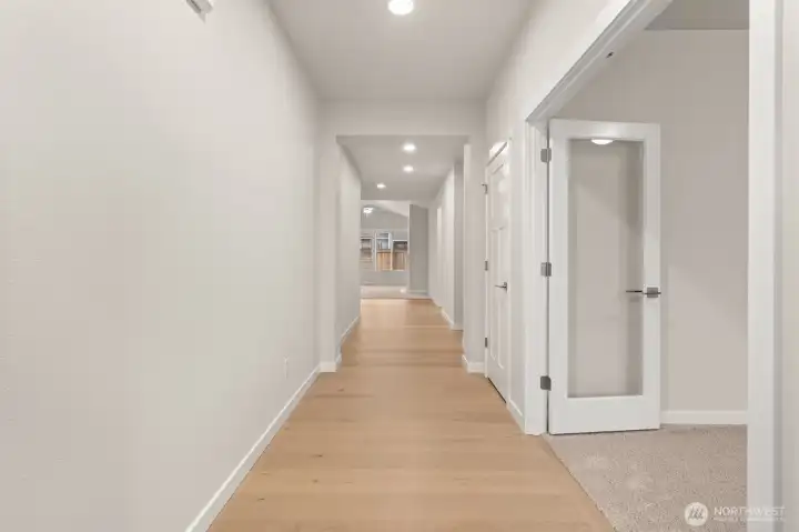Entryway featuring hardwood floors extended through hallway.