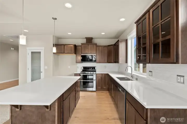 Beautiful quartz countertops and full tile backsplash. Frosted door leads to pantry.